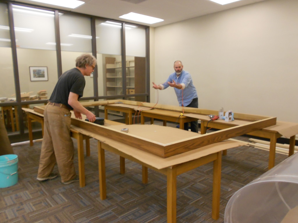 The oak frame after assembly with framer Bill Renschler, left, and his assistant Mark.   The frame was brought up the library disassembled and assembled onsite.  The frame pieces were carried up a stairwell where the stairwell windows had to be opened and the frame pieces slipped out the window to clear the stairwells’ hairpin turns.    