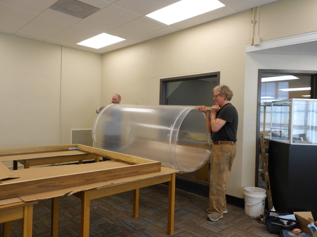 The unrolling of the Plexiglas, the map’s new protective glazing.