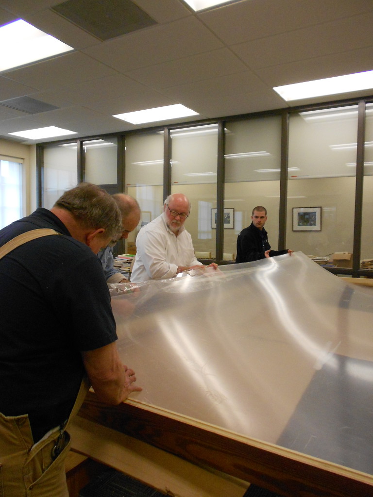 All hands on deck to roll out the Plexiglas.  Kevin Grace, center, Head of the Archives and Rare Books Library.