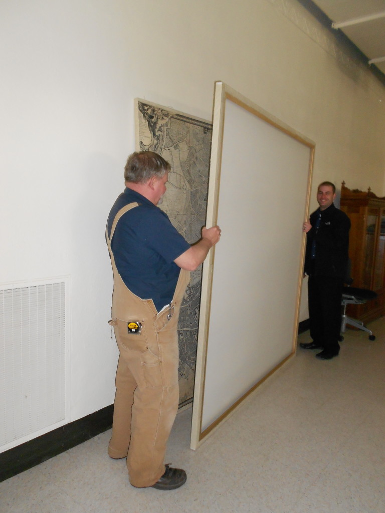 The map sections back together and being admired by our carpenter, Alan, and library facilities coordinator, Joe Volker.