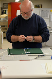 Kevin Grace, head of the Archives and Rare Books Library (UC), adhering all his Velcro pieces.